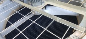 Top view inside a cooling tower showing drift eliminators positioned below the fan and metal safety grating, illustrating internal structure and air flow components.