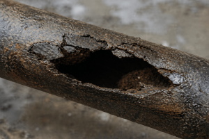 Severely corroded pipe with major metal loss and failure caused by long-term internal corrosion and poor water treatment control.