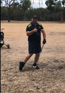 A Tandex service technician standing on a golf course holding a golf club and smiling during a company golf day event.
