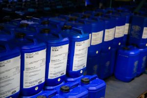 Rows of blue 15-litre Tandex chemical drums labelled “Polytan P” neatly arranged in the factory storage area, ready for dispatch or use in production.