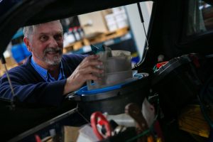 A Tandex technician smiling while packing tools and equipment into a service vehicle, preparing for customer site visits.