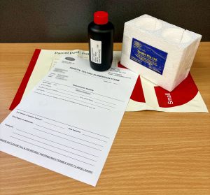 Remote water testing kit including sample bottle, submission form, and protective packaging used to send system water samples for laboratory analysis.