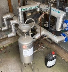 Chemical dosing pot in plant room Chemical dosing pot installed in a plant room used to safely introduce water treatment chemicals into a heating hot water system.